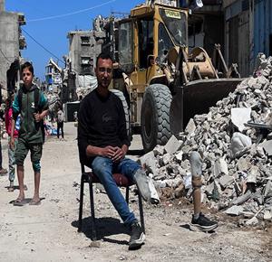 الشاب محمود كحيل فقد ساقه بغارة إسرائيلية، يعود إلى عمله سائقا لجرافة لإزالة أنقاض المنازل المدمرة، وتمهيد الطرق في مدينة غزة